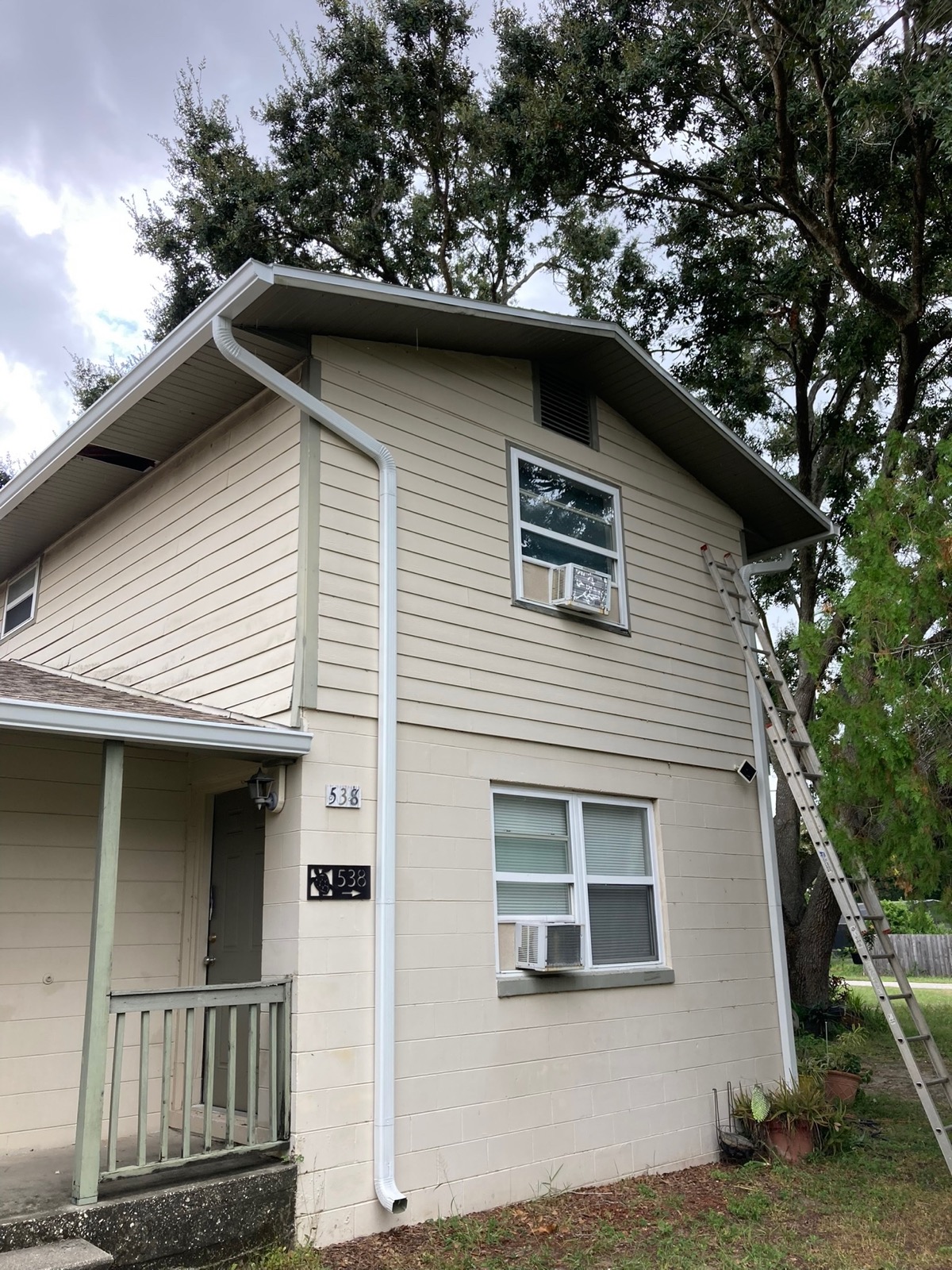 Fresh white seamless gutter install on a two-story Central Florida home